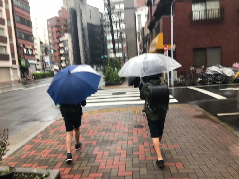 傘をさす小学生の後ろ姿